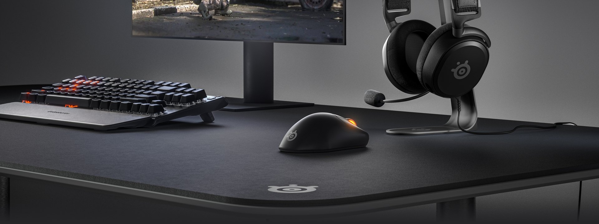 A sleek desktop setup feature a Prime mouse and headset.