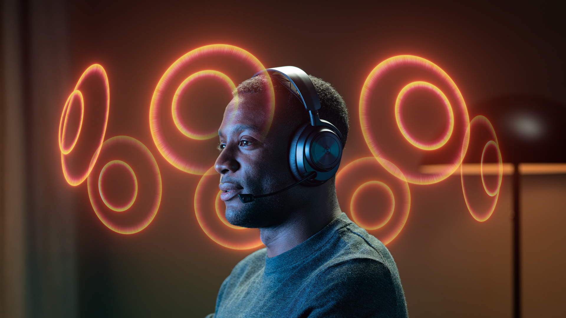 A person wearing an Arctis Nova headset with abstract orbs hovering around them to illustrate spatial audio.